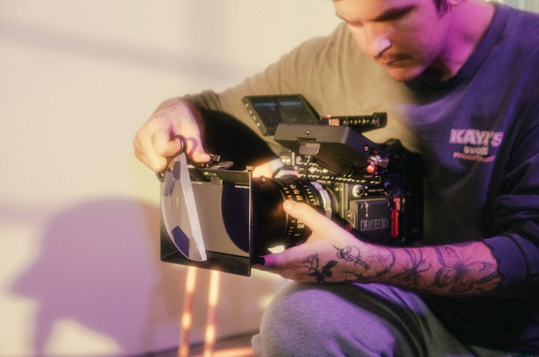 Two filmmakers reviewing footage together on a laptop in a small studio