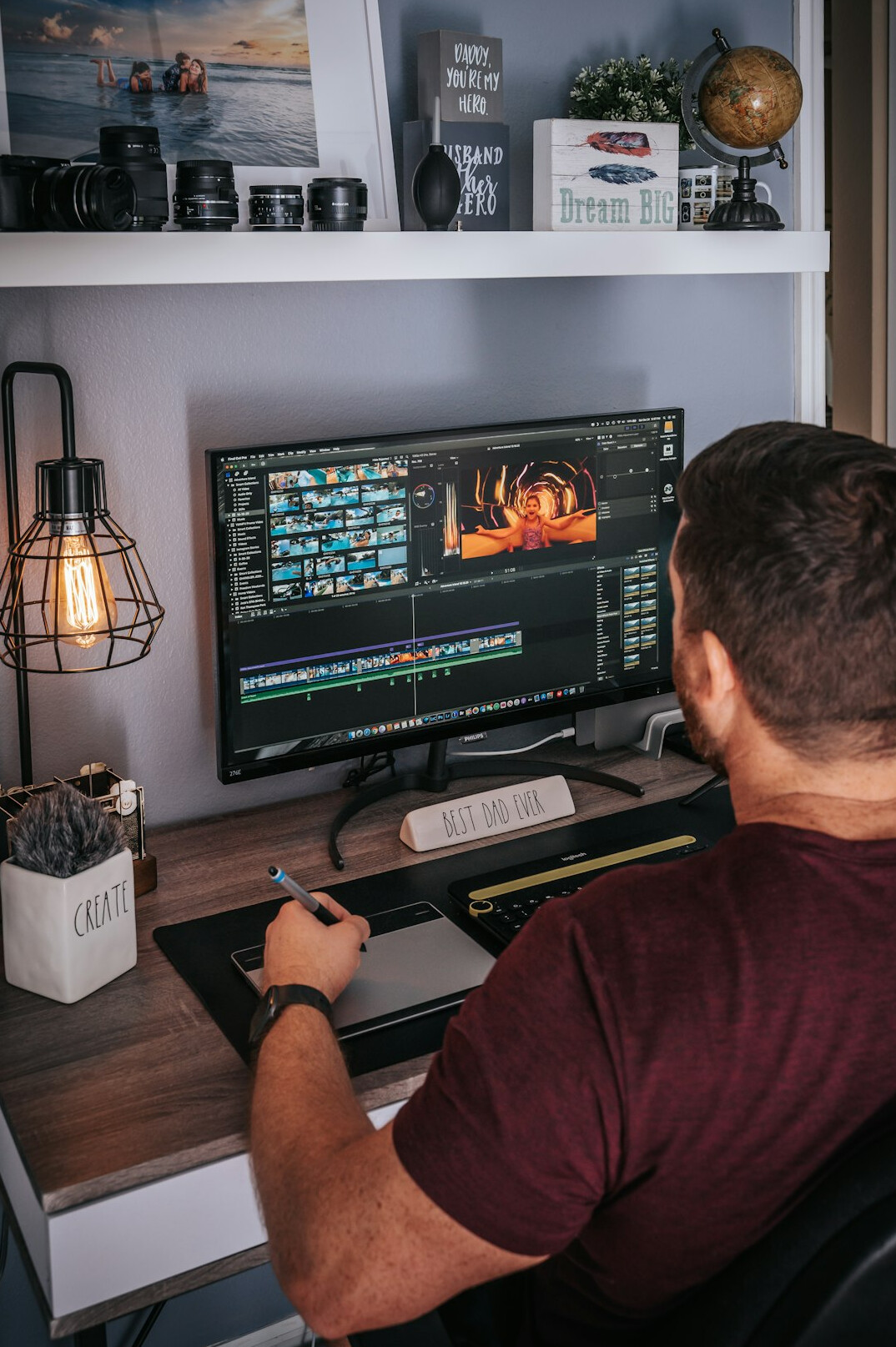 video editor at desk with multiple screens